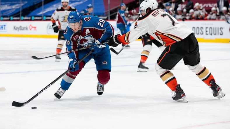 Mar 29, 2021; Denver, Colorado, USA; Colorado Avalanche center Nathan MacKinnon (29) controls the puck against Anaheim Ducks defenseman Ben Hutton (7) in the second period at Ball Arena. Mandatory Credit: Isaiah J. Downing-USA TODAY Sports