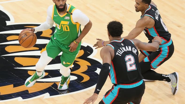 Mar 31, 2021; Memphis, Tennessee, USA; Utah Jazz guard Mike Conley (10) drives against center Memphis Grizzlies Xavier Tillman (2) and guard De'Anthony Melton (0) during the first quarter at FedExForum. Mandatory Credit: Nelson Chenault-USA TODAY Sports