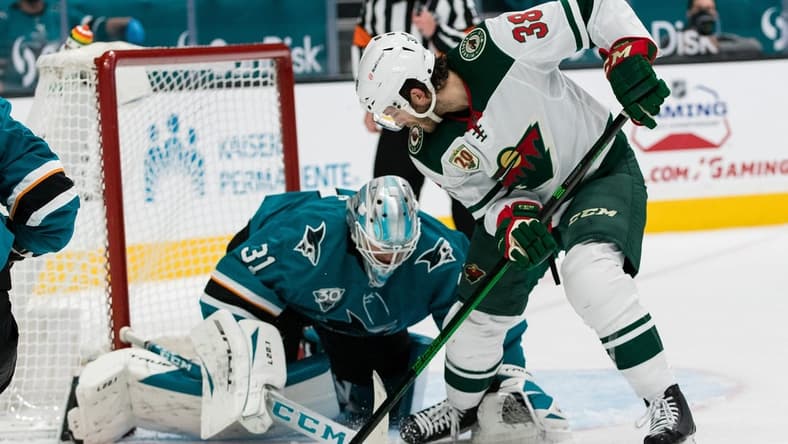 Mar 31, 2021; San Jose, California, USA; San Jose Sharks goaltender Martin Jones (31) battles for the puck with Minnesota Wild right wing Ryan Hartman (38) during the first period at SAP Center at San Jose. Mandatory Credit: John Hefti-USA TODAY Sports