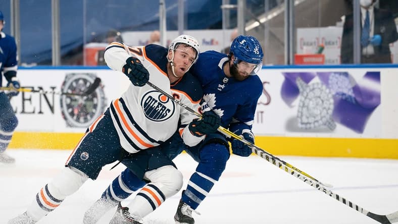 Mar 27, 2021; Toronto, Ontario, CAN; Toronto Maple Leafs center Alexander Kerfoot (15) battles for a puck with Edmonton Oilers center Connor McDavid (97) during the third period at Scotiabank Arena. Mandatory Credit: Nick Turchiaro-USA TODAY Sports