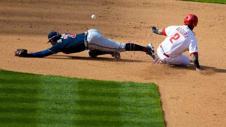 Apr 1, 2021; Philadelphia, Pennsylvania, USA; Atlanta Braves shortstop Dansby Swanson (7) is unable to field a throw as Philadelphia Phillies shortstop Jean Segura (2) slides safely into second base during the fourth inning at Citizens Bank Park. Mandatory Credit: Bill Streicher-USA TODAY Sports