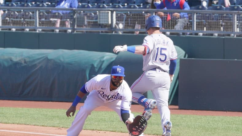 Apr 1, 2021; Kansas City, Missouri, USA; Kansas City Royals first baseman Carlos Santana (41) makes the out on Texas Rangers second baseman Nick Solak (15) at first base in the first inning at Kauffman Stadium. Mandatory Credit: Denny Medley-USA TODAY Sports