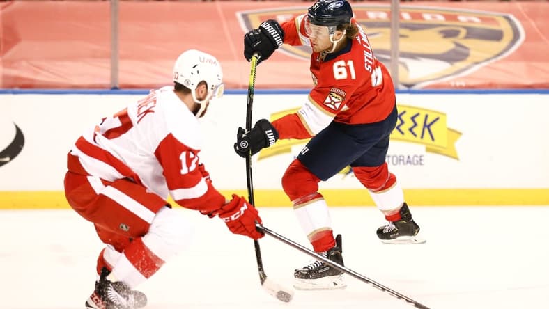 Apr 1, 2021; Sunrise, Florida, USA; Florida Panthers defenseman Riley Stillman (61) shoots the puck around Detroit Red Wings defenseman Filip Hronek (17) during the second period at BB&T Center. Mandatory Credit: Sam Navarro-USA TODAY Sports