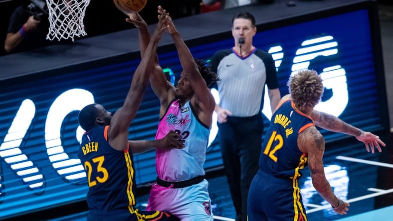 Apr 1, 2021; Miami, Florida, USA; Miami Heat forward Jimmy Butler (22) passes the ball over Golden State Warriors forward Draymond Green (23) during the second quarter of a game at American Airlines Arena. Mandatory Credit: Mary Holt-USA TODAY Sports