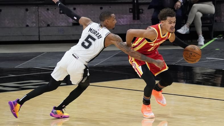 Apr 1, 2021; San Antonio, Texas, USA; Atlanta Hawks guard Trae Young (11) dribbles up court as San Antonio Spurs guard Dejounte Murray (5) reaches in for a foul in the fourth quarter at AT&T Center. Mandatory Credit: Scott Wachter-USA TODAY Sports