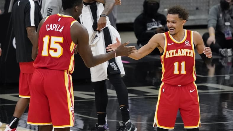 Apr 1, 2021; San Antonio, Texas, USA; Atlanta Hawks center Clint Capela (15) and guard Trae Young (11) celebrate after their double overtime victory over the San Antonio Spurs at AT&T Center. Mandatory Credit: Scott Wachter-USA TODAY Sports