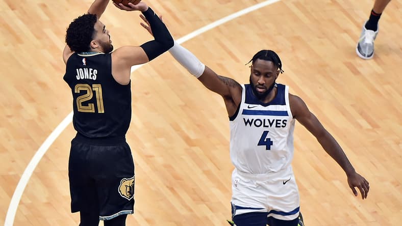 Apr 2, 2021; Memphis, Tennessee, USA;  Memphis Grizzlies guard Tyus Jones (21) shoots against Minnesota Timberwolves guard Jaylen Nowell (4) during the first half at FedExForum. Mandatory Credit: Justin Ford-USA TODAY Sports