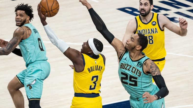 Apr 2, 2021; Indianapolis, Indiana, USA; Indiana Pacers guard Aaron Holiday (3) shoots the ball while Charlotte Hornets forward P.J. Washington (25) defends in the second quarter at Bankers Life Fieldhouse. Mandatory Credit: Trevor Ruszkowski-USA TODAY Sports