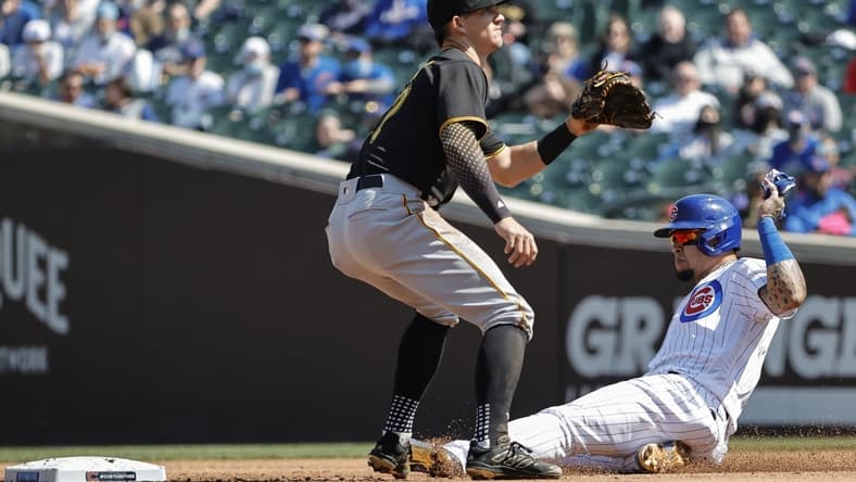 Apr 3, 2021; Chicago, Illinois, USA; Chicago Cubs shortstop Javier Baez (9) steals the second base as Pittsburgh Pirates shortstop Kevin Newman (27) waits for the ball in the second inning at Wrigley Field. Mandatory Credit: Kamil Krzaczynski-USA TODAY Sports