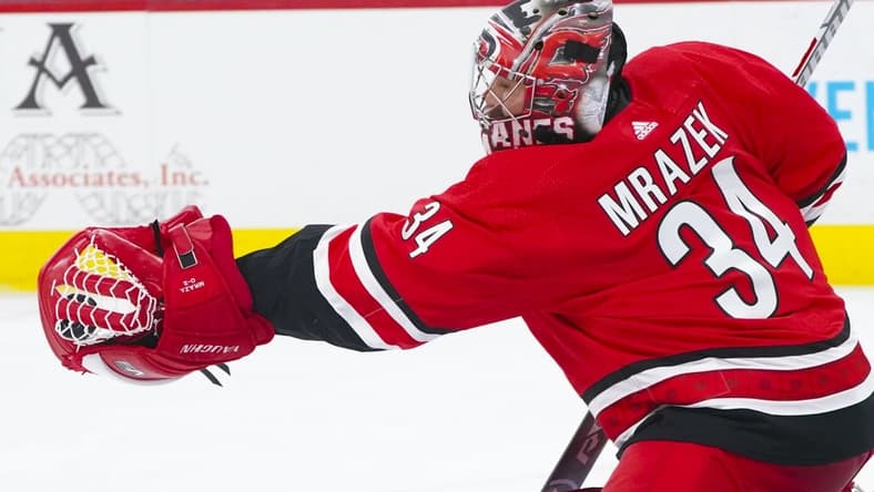 Apr 4, 2021; Raleigh, North Carolina, USA; Carolina Hurricanes goaltender Petr Mrazek (34) makes a second period glove save against the Dallas Stars at PNC Arena. Mandatory Credit: James Guillory-USA TODAY Sports