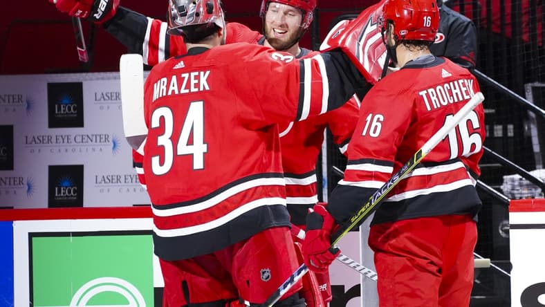 Apr 4, 2021; Raleigh, North Carolina, USA; Carolina Hurricanes goaltender Petr Mrazek (34) and defenseman Jaccob Slavin (74) and center Vincent Trocheck (16) celebrate the win against the Dallas Stars at PNC Arena. Mandatory Credit: James Guillory-USA TODAY Sports