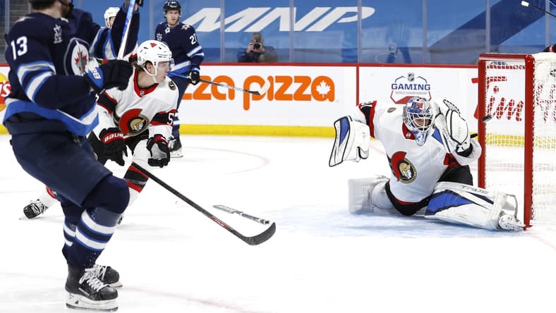Apr 5, 2021; Winnipeg, Manitoba, CAN; Winnipeg Jets left wing Pierre-Luc Dubois (13) scores on Ottawa Senators goaltender Anton Forsberg (31) in the second period at Bell MTS Place. Mandatory Credit: James Carey Lauder-USA TODAY Sports