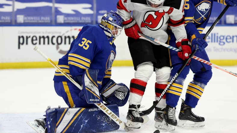 Apr 8, 2021; Buffalo, New York, USA; New Jersey Devils left wing Miles Wood (44) tries to deflect a shot on Buffalo Sabres goaltender Linus Ullmark (35) during the first period at KeyBank Center. Mandatory Credit: Timothy T. Ludwig-USA TODAY Sports