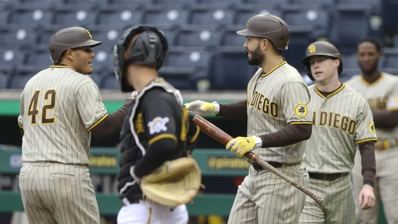Apr 15, 2021; Pittsburgh, Pennsylvania, USA; San Diego Padres third baseman Manny Machado (left) is congratulated by San Diego Padres first baseman Eric Hosmer (30) after hitting a two run home run as Pittsburgh Pirates catcher Jacob Stallings (middle) looks on during the first inning at PNC Park. Mandatory Credit: Charles LeClaire-USA TODAY Sports