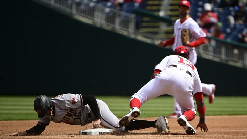 Apr 17, 2021; Washington, District of Columbia, USA; Arizona Diamondbacks left fielder Tim Locastro (16) slides through the plate after being tagged out by Washington Nationals second baseman Starlin Castro (13) during the third inning at Nationals Park. Mandatory Credit: Tommy Gilligan-USA TODAY Sports