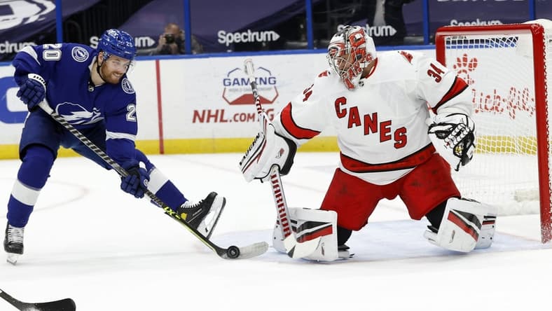 Apr 19, 2021; Tampa, Florida, USA; Tampa Bay Lightning center Blake Coleman (20) shoots as Carolina Hurricanes goaltender Petr Mrazek (34) defends during the first period at Amalie Arena. Mandatory Credit: Kim Klement-USA TODAY Sports