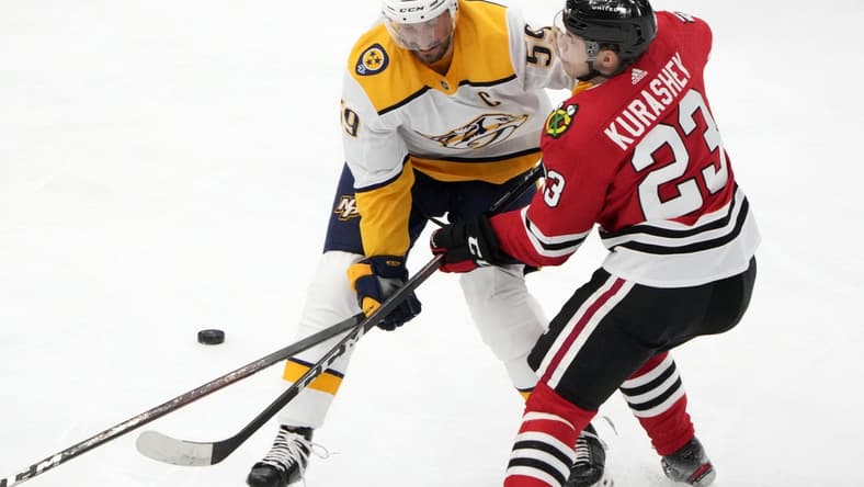 Apr 21, 2021; Chicago, Illinois, USA; Nashville Predators defenseman Roman Josi (59) checks Chicago Blackhawks left wing Philipp Kurashev (23) during the first period at the United Center. Mandatory Credit: Mike Dinovo-USA TODAY Sports