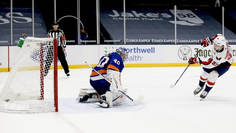Apr 22, 2021; Uniondale, New York, USA; Washington Capitals center Evgeny Kuznetsov (92) scores the game deciding goal against New York Islanders goaltender Semyon Varlamov (40) during the shootout at Nassau Veterans Memorial Coliseum. Mandatory Credit: Andy Marlin-USA TODAY Sports