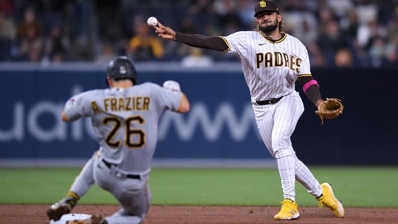 May 3, 2021; San Diego, California, USA; San Diego Padres shortstop Fernando Tatis Jr. (R) throws to first base on a ground out by Pittsburgh Pirates center fielder Bryan Reynolds (not pictured) as second baseman Adam Frazier (26) slides into second base during the fifth inning at Petco Park. Mandatory Credit: Orlando Ramirez-USA TODAY Sports