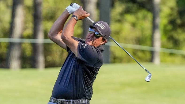 May 6, 2021; Charlotte, North Carolina, USA; Phil Mickelson hits his approach shot to the 9th green during the first round of the Wells Fargo Championship golf tournament. Mandatory Credit: Jim Dedmon-USA TODAY Sports