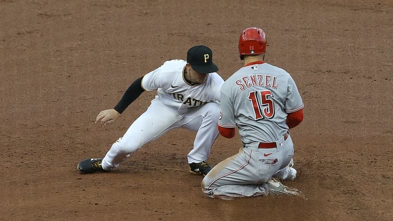 May 11, 2021; Pittsburgh, Pennsylvania, USA; Pittsburgh Pirates shortstop Kevin Newman (L) tags out Cincinnati Reds second baseman Nick Senzel (15) attempting to steal second base during the third inning at PNC Park. Mandatory Credit: Charles LeClaire-USA TODAY Sports