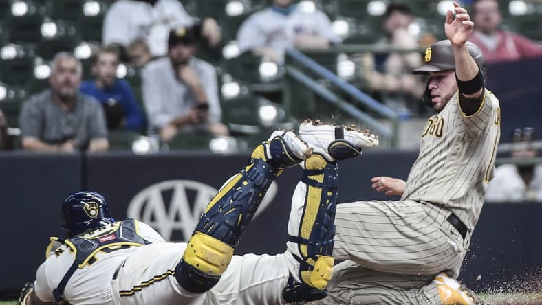 May 25, 2021; Milwaukee, Wisconsin, USA; San Diego Padres catcher Victor Caratini (right) scores on a double steal during the third inning as Milwaukee Brewers catcher Omar Narvaez (left) attempts to make a tag at American Family Field. Mandatory Credit: Benny Sieu-USA TODAY Sports