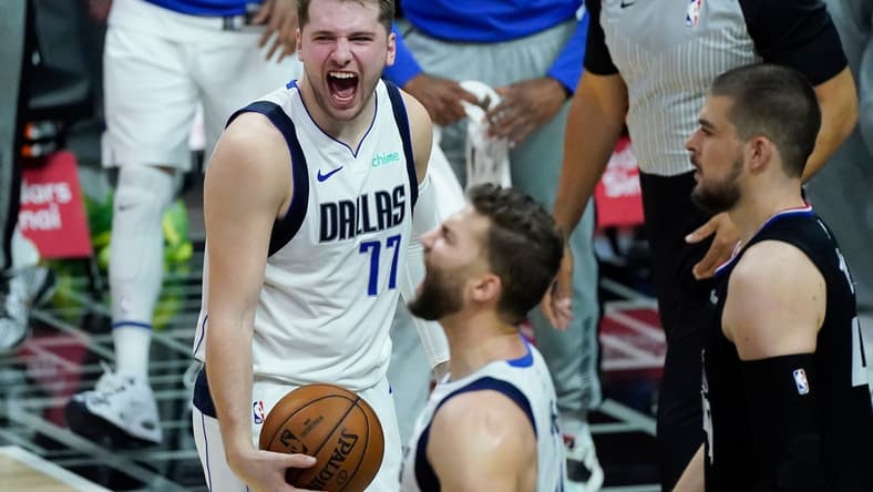 May 25, 2021; Los Angeles, California, USA; Dallas Mavericks guard Luka Doncic (77) and forward Maxi Kleber (foreground) react after defeating the LA Clippers in game two of the first round of the 2021 NBA Playoffs at Staples Center. Mandatory Credit: Robert Hanashiro-USA TODAY Sports