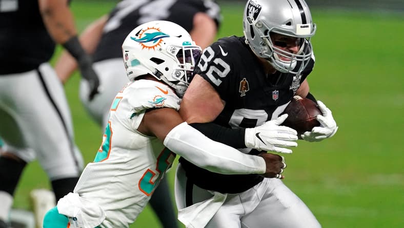 Dec 26, 2020; Paradise, Nevada, USA; Miami Dolphins outside linebacker Jerome Baker (55) tackles Las Vegas Raiders tight end Jason Witten (82) during the first half at Allegiant Stadium. Mandatory Credit: Kirby Lee-USA TODAY Sports