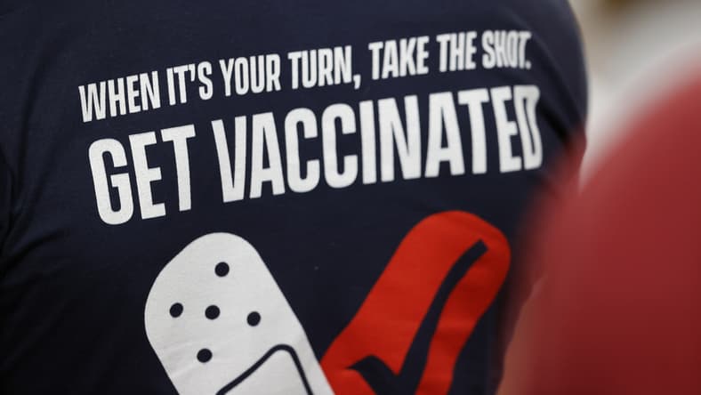 Feb 7, 2020; Tampa, FL, USA; A fan wears a shirt reminding people to get a COVID-19 vaccine during the first quarter of Super Bowl LV between the Kansas City Chiefs and the Tampa Bay Buccaneersat Raymond James Stadium. Mandatory Credit: Kim Klement-USA TODAY Sports
