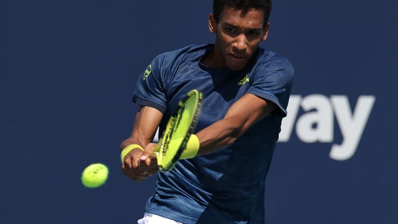 Mar 28, 2021; Miami, Florida, USA; Felix Auger-Aliassime of Canada hits a backhand against John Isner of the United States (not pictured) in the third round in the Miami Open at Hard Rock Stadium. Mandatory Credit: Geoff Burke-USA TODAY Sports