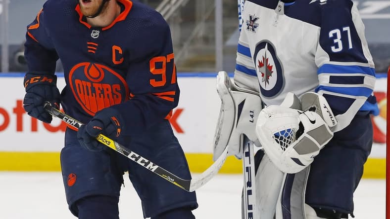 May 21, 2021; Edmonton, Alberta, CAN; Edmonton Oilers forward Connor McDavid (97) tries to screen Winnipeg Jets goaltender Connor Hellebuyck (37) during the third period in game two of the first round of the 2021 Stanley Cup Playoffs at Rogers Place. Mandatory Credit: Perry Nelson-USA TODAY Sports