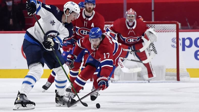 Jun 7, 2021; Montreal, Quebec, CAN; Winnipeg Jets defenseman Logan Stanley (64) plays the puck and Montreal Canadiens forward Josh Anderson (17) defends during the second period in game four of the second round of the 2021 Stanley Cup Playoffs at the Bell Centre. Mandatory Credit: Eric Bolte-USA TODAY Sports