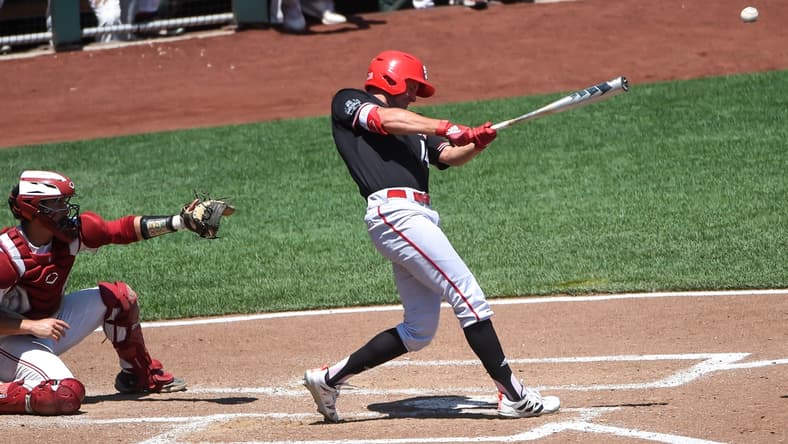 Jun 19, 2021; Omaha, Nebraska, USA;  NC State Wolfpack outfielder Jonny Butler (14) singles in two runs in the fourth inning against the Stanford Cardinal at TD Ameritrade Park. Mandatory Credit: Steven Branscombe-USA TODAY Sports