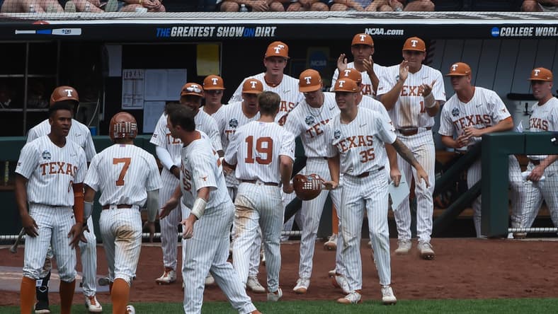 Jun 22, 2021; Omaha, Nebraska, USA; The Texas Longhorns bench celebrates with outfielder Douglas Hodo (7) and infielder Mitchell Daly (19) after scoring in the fourth inning against the Tennessee Volunteers at TD Ameritrade Park. Mandatory Credit: Steven Branscombe-USA TODAY Sports