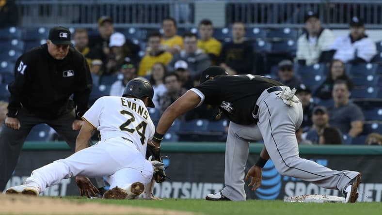 Jun 22, 2021; Pittsburgh, Pennsylvania, USA; Pittsburgh Pirates left fielder Phillip Evans (24) is tagged out at first base by Chicago White Sox first baseman Jose Abreu (79) on a pick-off during the second inning at PNC Park. Mandatory Credit: Charles LeClaire-USA TODAY Sports
