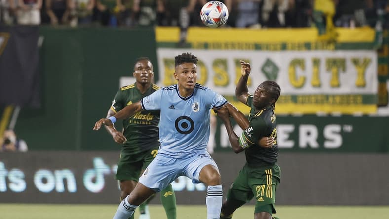 Jun 26, 2021; Portland, Oregon, USA; Minnesota United forward Juan Agudelo (21) and Portland Timbers midfielder Diego Chara (21) battle for the ball during the second half at Providence Park. Mandatory Credit: Soobum Im-USA TODAY Sports