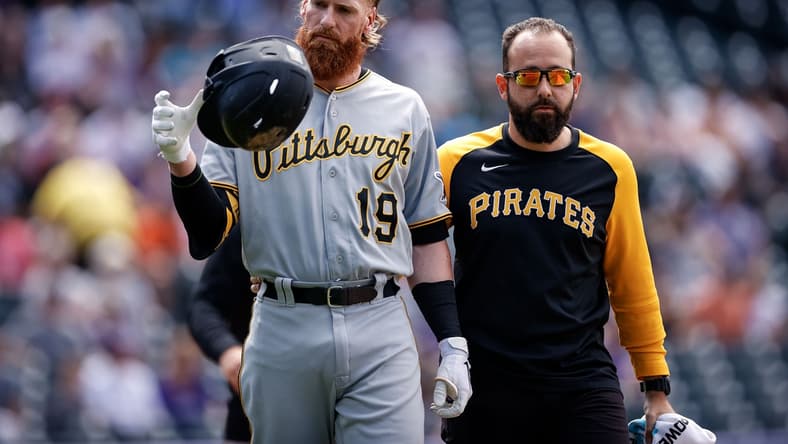 Jun 28, 2021; Denver, Colorado, USA; Pittsburgh Pirates first baseman Colin Moran (19) walks to first with strength and conditioning coach Terence Brannic after being hit by a pitch in the first inning Colorado Rockies at Coors Field. Mandatory Credit: Isaiah J. Downing-USA TODAY Sports