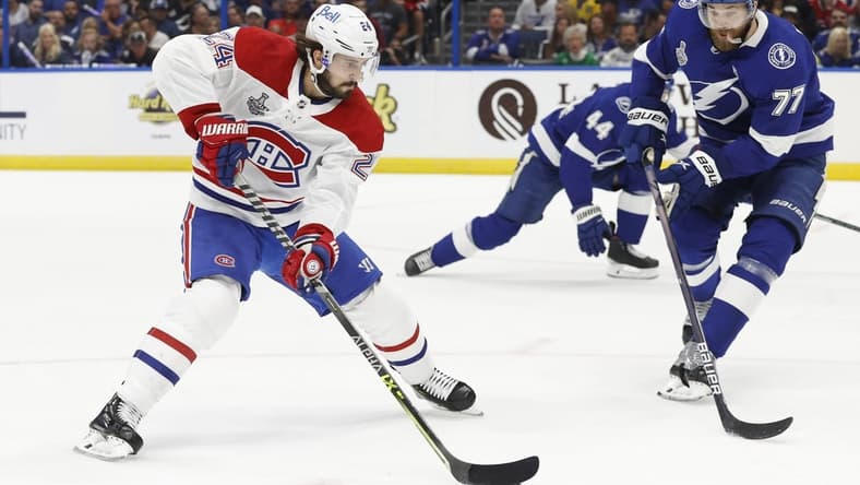 Jun 28, 2021; Tampa, Florida, USA; Montreal Canadiens left wing Phillip Danault (24) skates with the puck against Tampa Bay Lightning defenseman Victor Hedman (77) in the first period of game one of the 2021 Stanley Cup Final at Amalie Arena. Mandatory Credit: Kim Klement-USA TODAY Sports