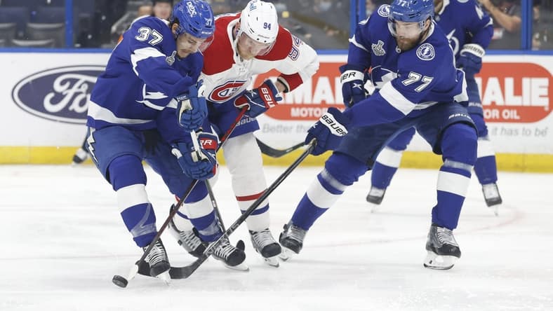 Jun 30, 2021; Tampa, Florida, USA;  Montreal Canadiens right wing Corey Perry (94) tries to get to the puck between Tampa Bay Lightning center Yanni Gourde (37) and defenseman Victor Hedman (77) during the first period in game two of the 2021 Stanley Cup Final at Amalie Arena. Mandatory Credit: Kim Klement-USA TODAY Sports
