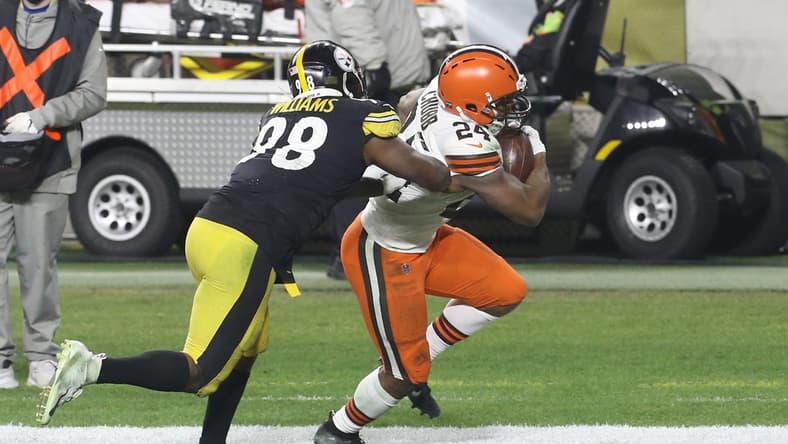 Jan 10, 2021; Pittsburgh, Pennsylvania, USA;  Cleveland Browns running back Nick Chubb (24) runs the ball against Pittsburgh Steelers inside linebacker Vince Williams (98) during the first quarter at Heinz Field. The Browns won 48-37. Mandatory Credit: Charles LeClaire-USA TODAY Sports