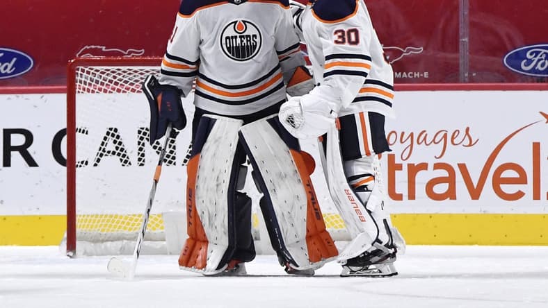 Feb 11, 2021; Montreal, Quebec, CAN; Edmonton Oilers goalie Mike Smith (41) celebrates the win over the Montreal Canadiens with teammate Dylan Wells (30) at the Bell Centre. Mandatory Credit: Eric Bolte-USA TODAY Sports
