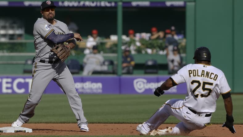 Jul 3, 2021; Pittsburgh, Pennsylvania, USA; Milwaukee Brewers second baseman Jace Peterson (14) throws to first base to completes a double play over the Pittsburgh Pirates pinch hitter right fielder Gregory Polanco (25) during the fifth inning at PNC Park. Mandatory Credit: Charles LeClaire-USA TODAY Sports