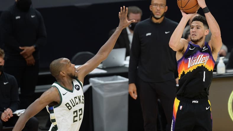 Jul 8, 2021; Phoenix, Arizona, USA; Phoenix Suns guard Devin Booker (1) shoots against Milwaukee Bucks forward Khris Middleton (22) during the second half in game two of the 2021 NBA Finals at Phoenix Suns Arena. Mandatory Credit: Joe Camporeale-USA TODAY Sports