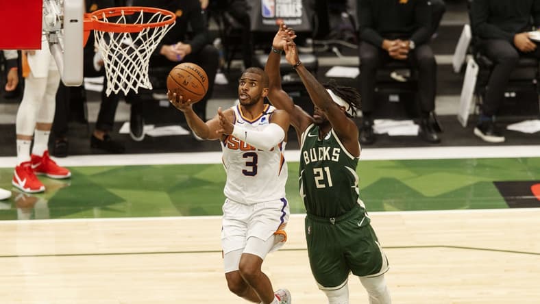 Jul 11, 2021; Milwaukee, Wisconsin, USA; Phoenix Suns guard Chris Paul (3) drives for a layup against Milwaukee Bucks guard Jrue Holiday (21) during the third quarter during game three of the 2021 NBA Finals at Fiserv Forum. Mandatory Credit: Jeff Hanisch-USA TODAY Sports