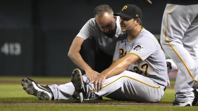 Jul 19, 2021; Phoenix, Arizona, USA; Pittsburgh Pirates starting pitcher Chase De Jong (37) gets checked by the trainer in the third inning against the Arizona Diamondbacks at Chase Field. Mandatory Credit: Rick Scuteri-USA TODAY Sports