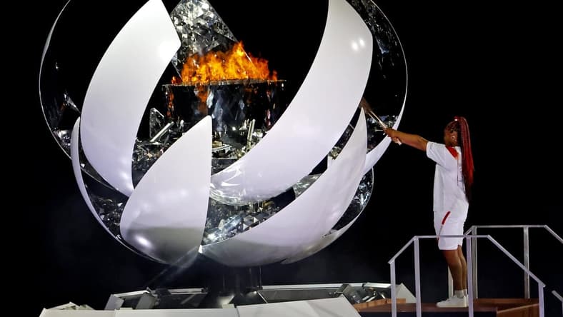 Jul 23, 2021; Tokyo, Japan; Naomi Osaka lights the Olympic flames during the opening ceremony for Tokyo 2020 Olympic Summer Games at Olympic Stadium. Mandatory Credit: Geoff Burke-USA TODAY Sports