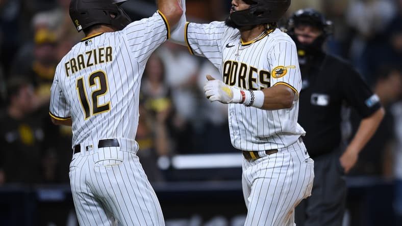 Jul 27, 2021; San Diego, California, USA; San Diego Padres shortstop Fernando Tatis Jr. (right) is congratulated by left fielder Adam Frazier (12) after hitting a two-run home run against the Oakland Athletics during the third inning at Petco Park. Mandatory Credit: Orlando Ramirez-USA TODAY Sports