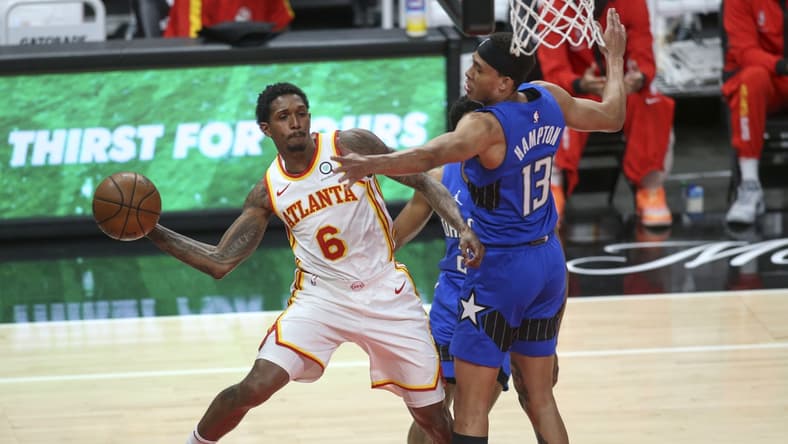 May 13, 2021; Atlanta, Georgia, USA; Atlanta Hawks guard Lou Williams (6) passes the ball around Orlando Magic guard R.J. Hampton (13) during the fourth quarter at State Farm Arena. Mandatory Credit: Brett Davis-USA TODAY Sports