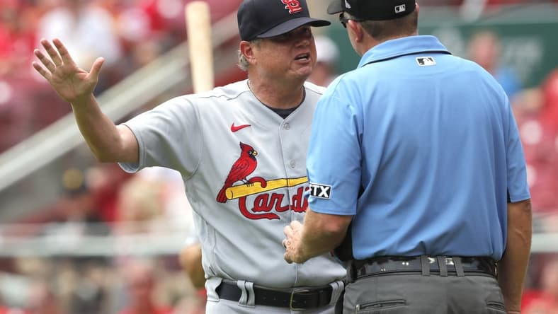 Jul 25, 2021; Cincinnati, Ohio, USA; St. Louis Cardinals manager Mike Shildt (left) discusses a call with first base umpire Ron Kulpa (right) during the second inning against the Cincinnati Reds at Great American Ball Park. Mandatory Credit: David Kohl-USA TODAY Sports