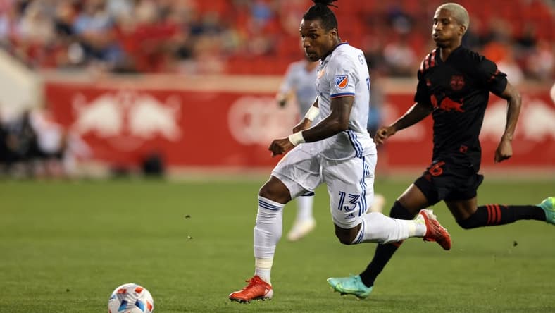 Aug 4, 2021; Harrison, New Jersey, USA; FC Cincinnati midfielder Joseph-Claude Gyau (13) moves the ball up the pitch against New York Red Bulls midfielder Dru Yearwood (16) during the first half at Red Bull Arena. Mandatory Credit: Vincent Carchietta-USA TODAY Sports